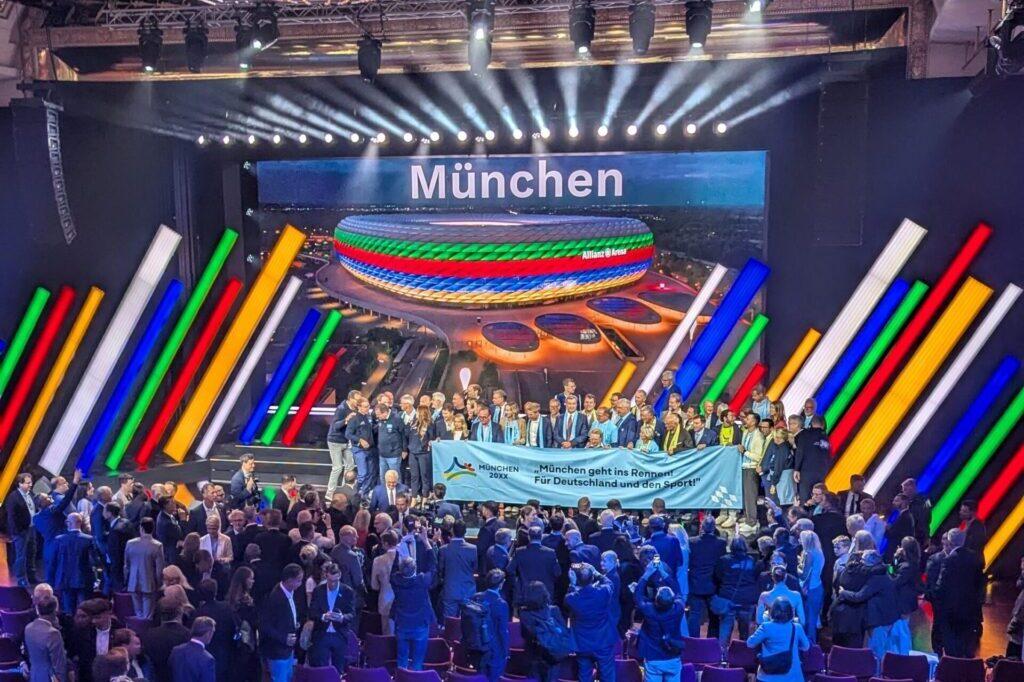 Gruppe von Menschen freut sich über die Zusage von München als Olympia-Bewerber