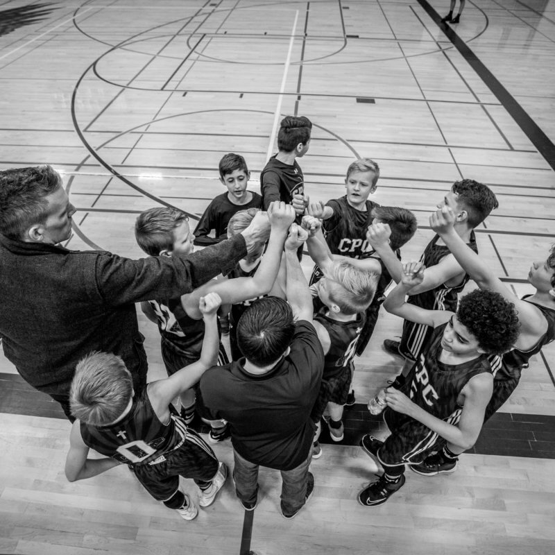 grayscale photography of boys raising hand