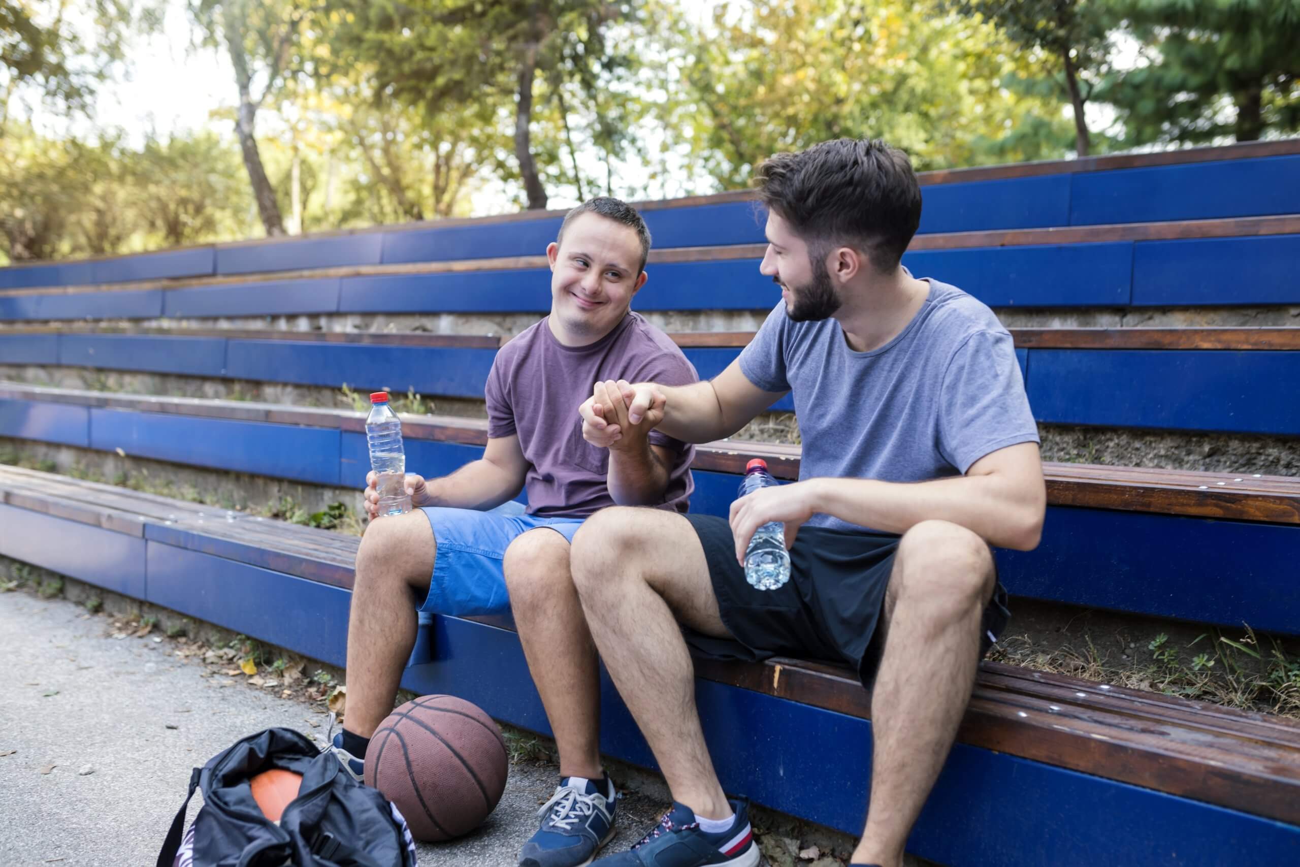 Zwei Männer sitzen auf einer Tribüne und machen Pause