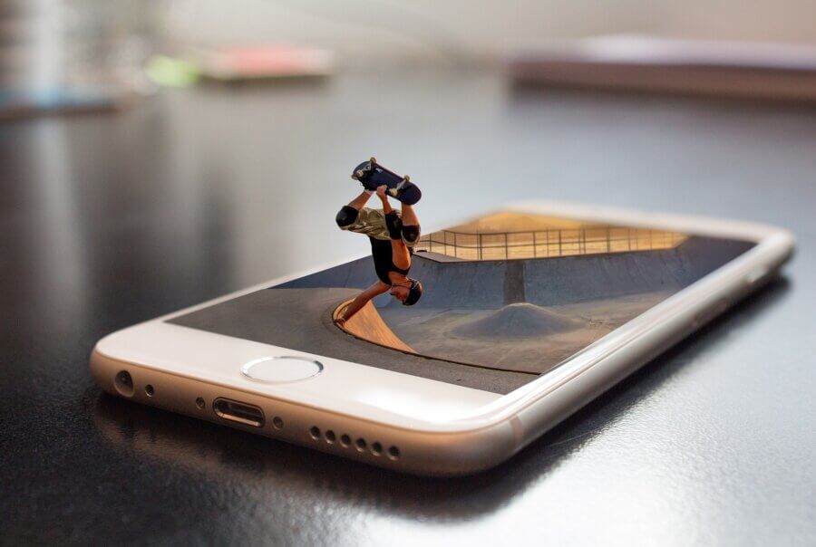 Ein Smartphone zeigt einen Skatepark. Aus dem Handy kommt ein Skater gesprungen